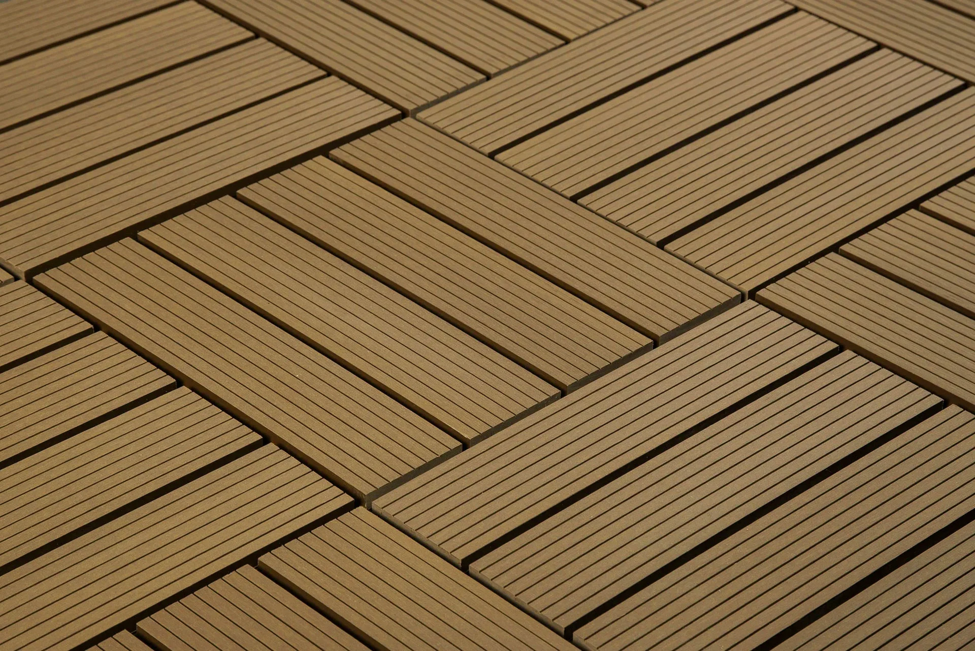 Close-up of interlocking wooden tiles arranged in a geometric, diagonal pattern. The tiles feature narrow, parallel slats, creating a modern and visually appealing design.
