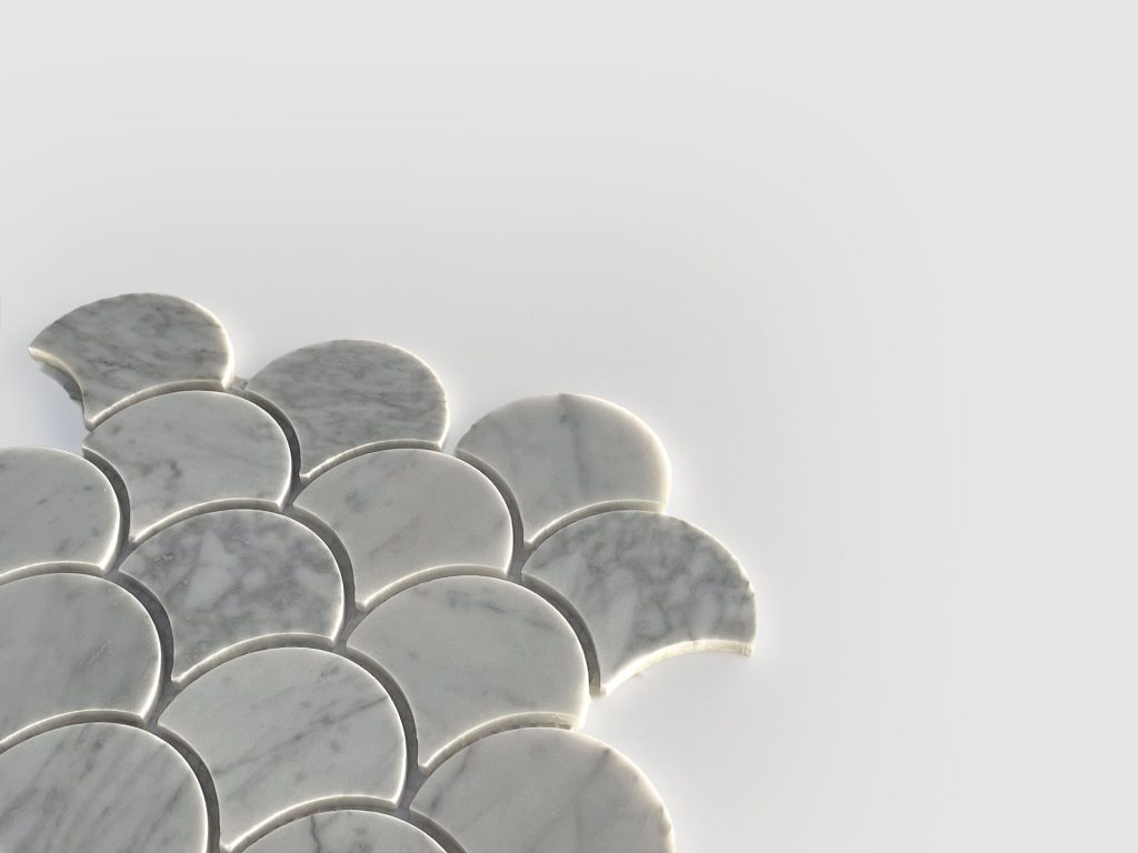 Several light gray, marble-patterned tiles shaped like scallop shells are arranged closely together on a plain, light background, forming a partial pattern with empty space around them.
