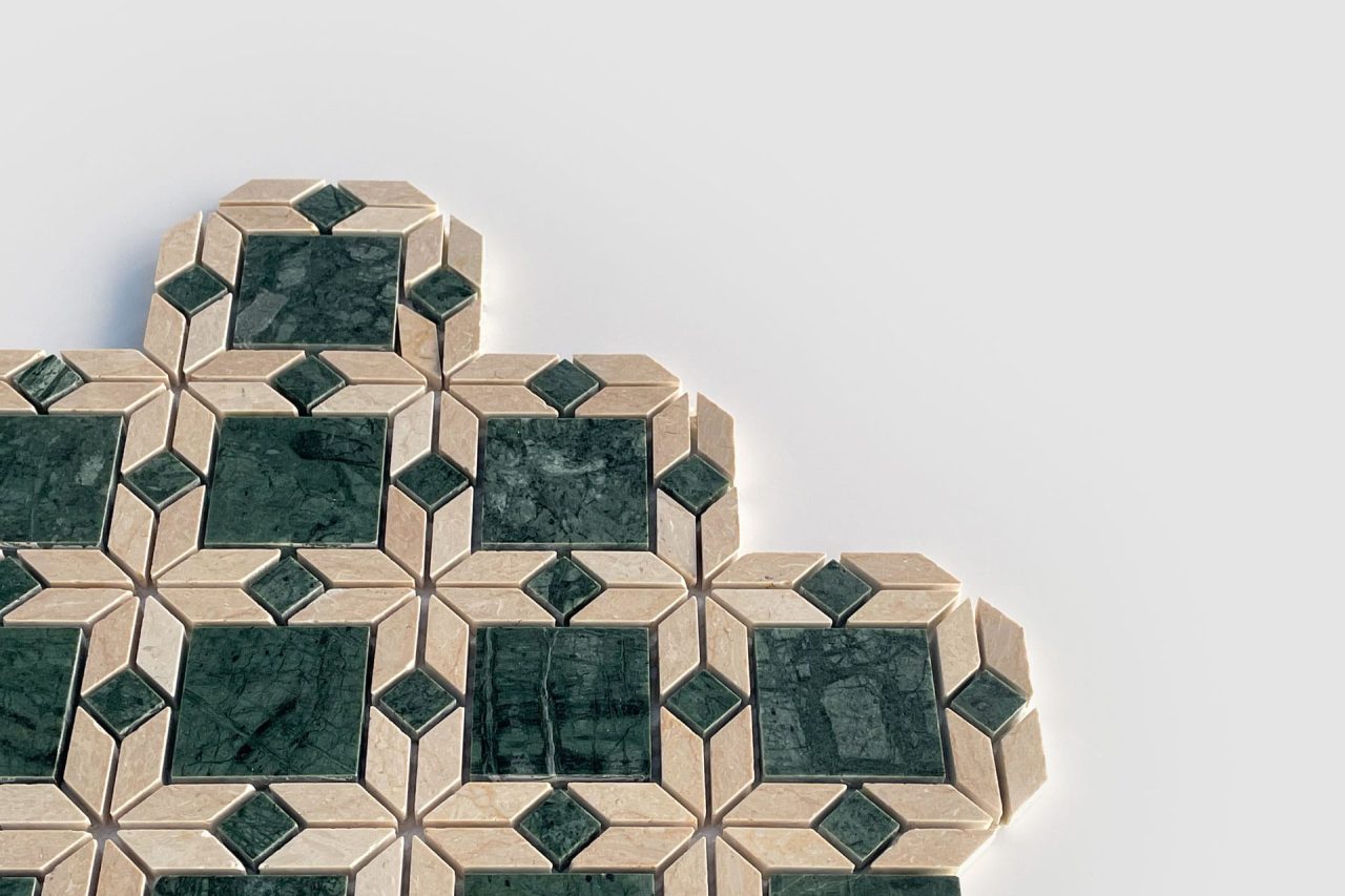 A geometric tile pattern featuring dark green square tiles bordered by beige and white diamond shapes, arranged in a repeating design against a plain white background.